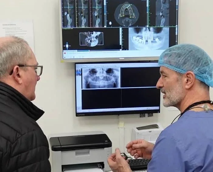 Oralkirurg snakker med pasient